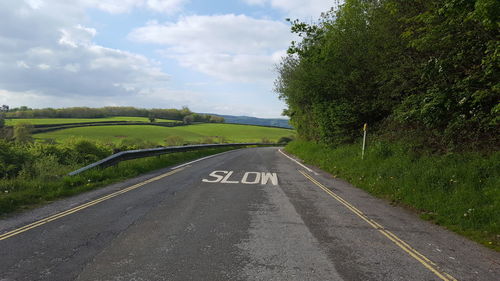 Text on empty road by field