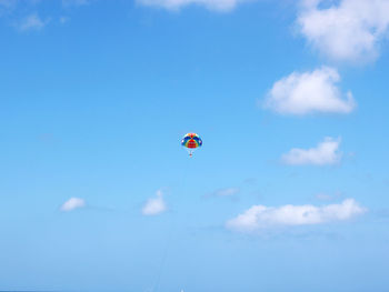 Low angle view of person paragliding against sky