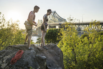 Two friends rock climbing together drinking water and taking a break