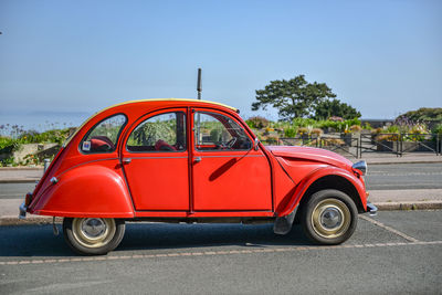 Vintage car on road against blue sky