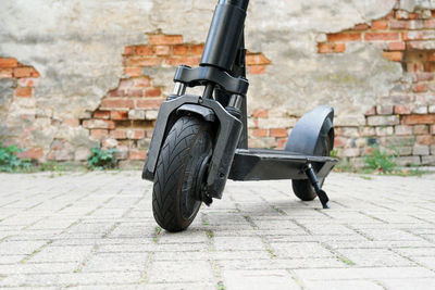 Side view of bicycle on sidewalk against wall