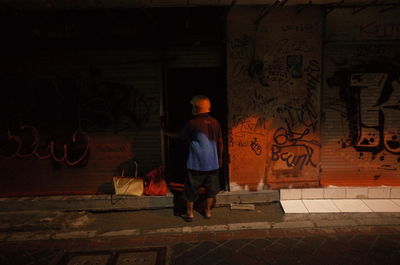 Rear view of woman walking on street at night