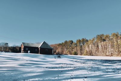 Snow covered landscape against clear blue sky