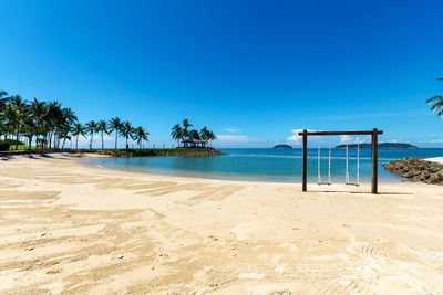 Scenic view of beach against clear blue sky