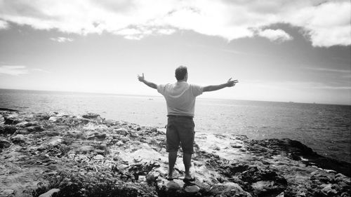 Rear view of man standing on beach