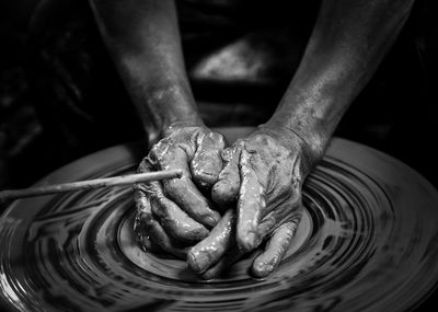 Cropped hand of person working with earthenware