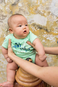 Parent holding cute baby boy outdoors