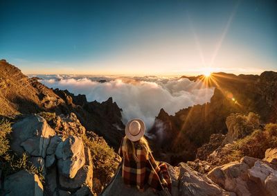 Panoramic view of man standing on mountain against sky