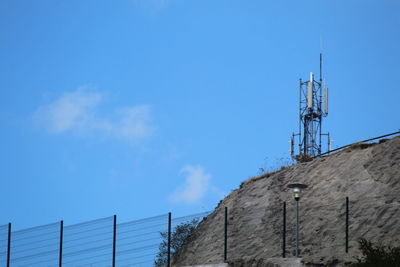 Low angle view of communications tower against blue sky