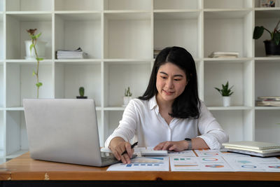Young woman using laptop at table
