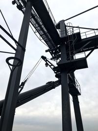 Low angle view of silhouette crane against sky