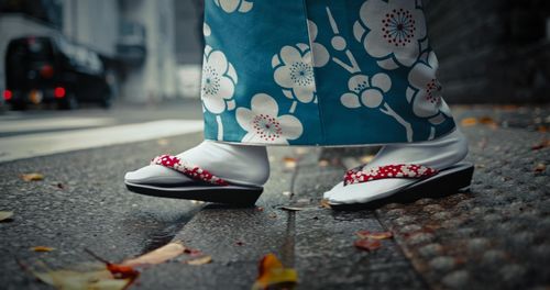 Low section of woman standing on street