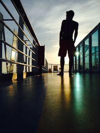 Silhouette man standing on bridge