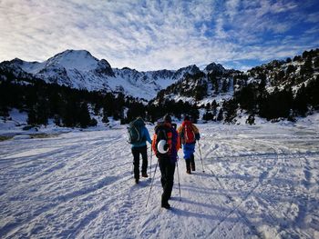 Full length of people on snowcapped mountains against sky