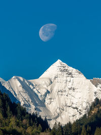 Low angle view of mountains against clear blue sky