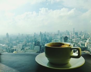 Close-up of tea in city against sky