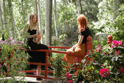 Happy ginger hair woman with friend in well-groomed park or garden. support and healthy way of life