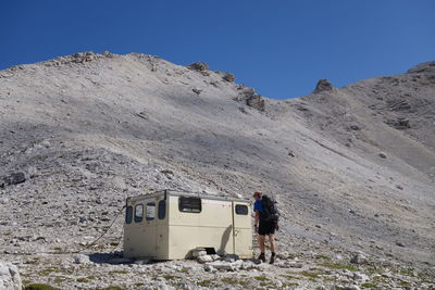 Mature man standing on mountain against clear sky