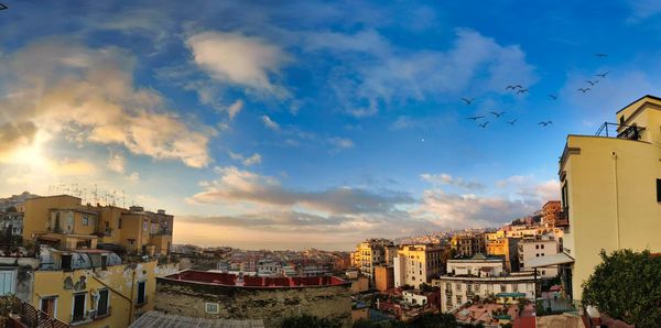 Buildings in city against sky during sunset