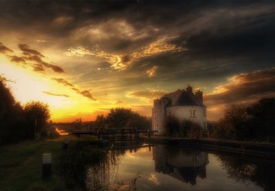 Scenic view of river against cloudy sky