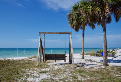 Lifeguard hut on beach against blue sky