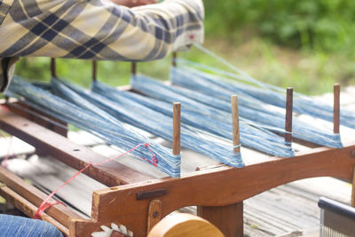 Midsection of man working on loom 