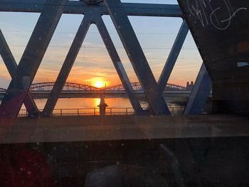 Bridge over river against sky during sunset