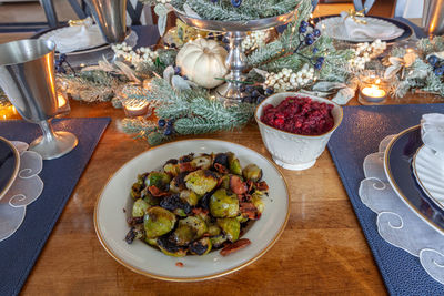 Brussels sprouts and cranberry chutney on fine bone china and a silver serving spoon at christmas.