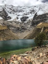 Scenic view of lake by mountains against sky