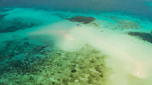 Sand bar among coral reefs in turquoise atoll water, top view. balabac, palawan, philippines.