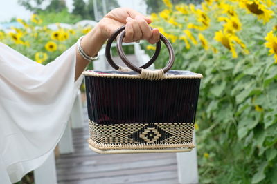 Close-up of yellow flower hanging on wicker basket