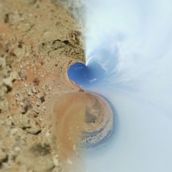 Waves on sand at beach against sky