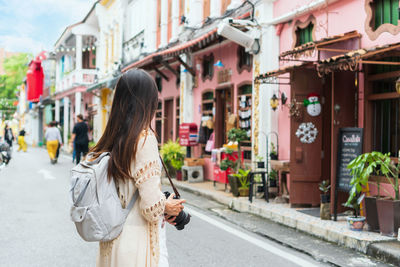 Rear view of woman standing in city