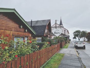 Houses by building against sky