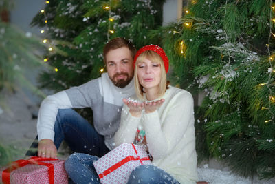 Portrait of smiling young woman sitting on snow