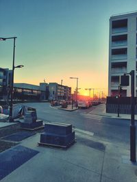 City street against clear sky at sunset