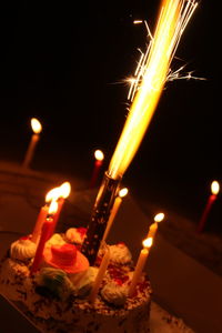 Close-up of lit candles at night