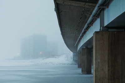 Bridge over river in city during winter