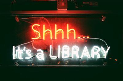 Close-up of illuminated text at store