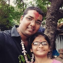 Portrait of smiling young man and woman against trees