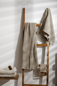 Towels hanging on wooden ladder against wall