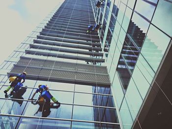 Low angle view of men working against sky