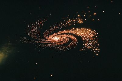 Low angle view of illuminated fireworks against sky at night