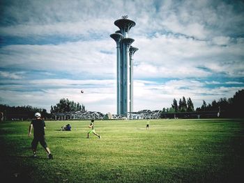 View of statue on field against cloudy sky