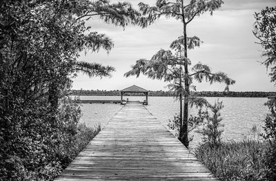 Wooden pier over lake against sky