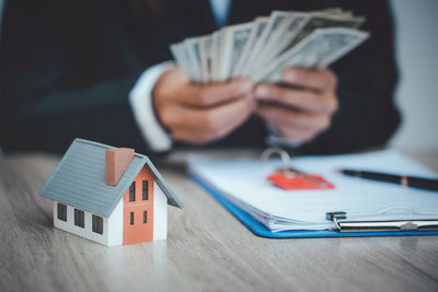 Close-up of a man holding paper house