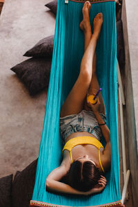 Rear view of woman lying on sofa