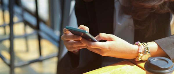 Midsection of woman using mobile phone