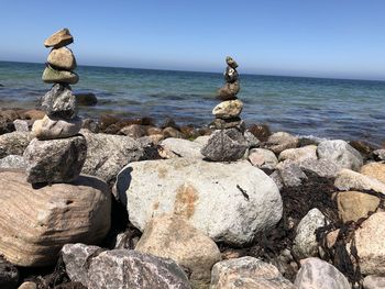 Rocks on sea shore against sky