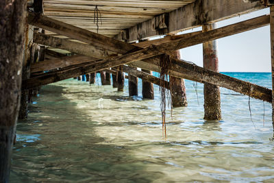 Low section of pier over sea against sky